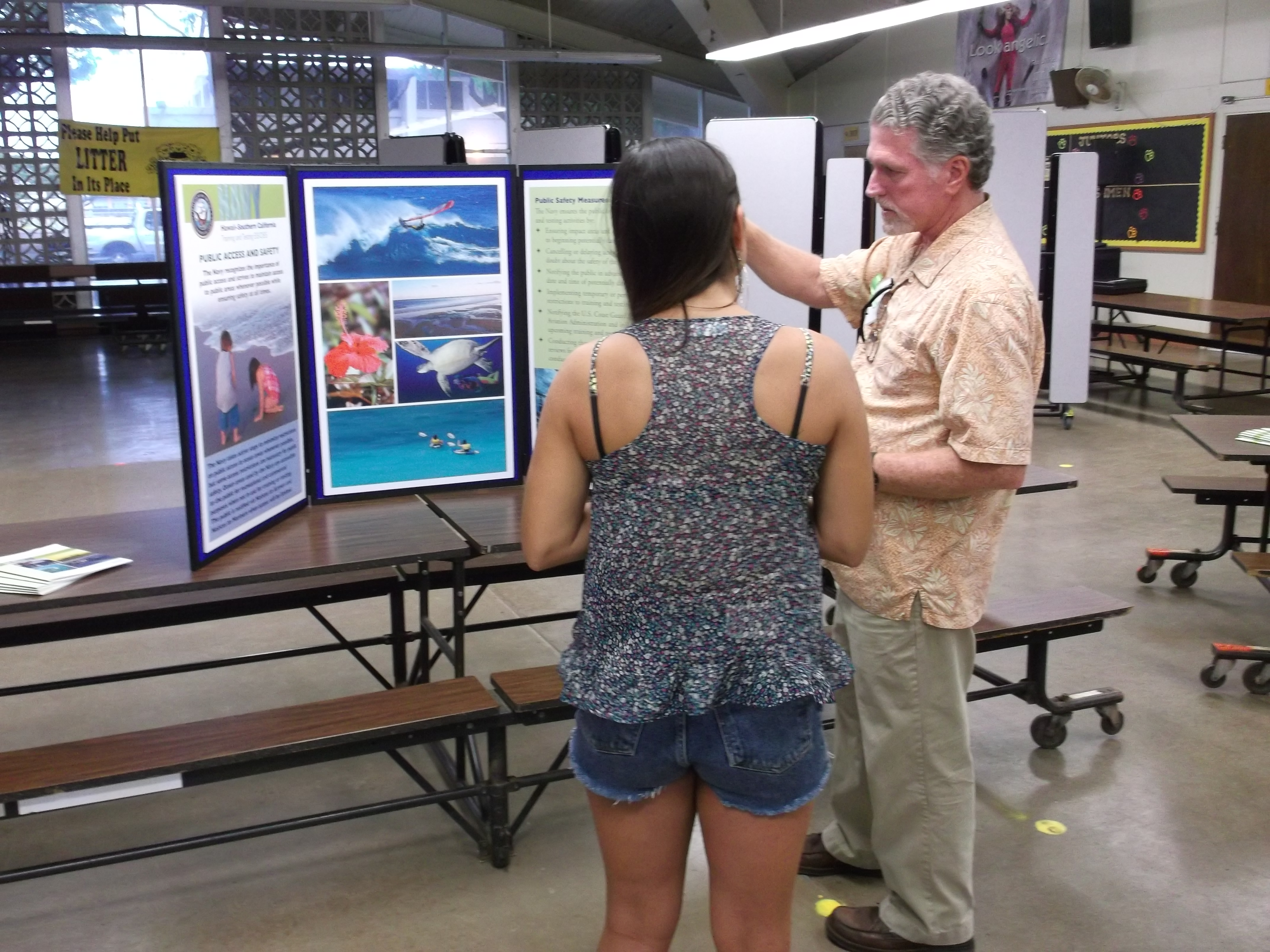 This is an image of a member of the public speaking with a project representative at a poster station during an in-person public meeting